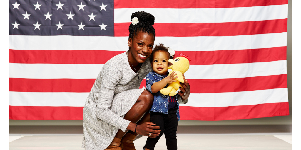 Alysia Montaño and her daughter pose in front of the American flag